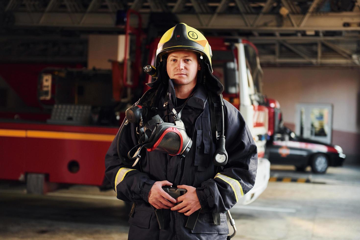 Female firefighter in protective uniform standing near truck photo