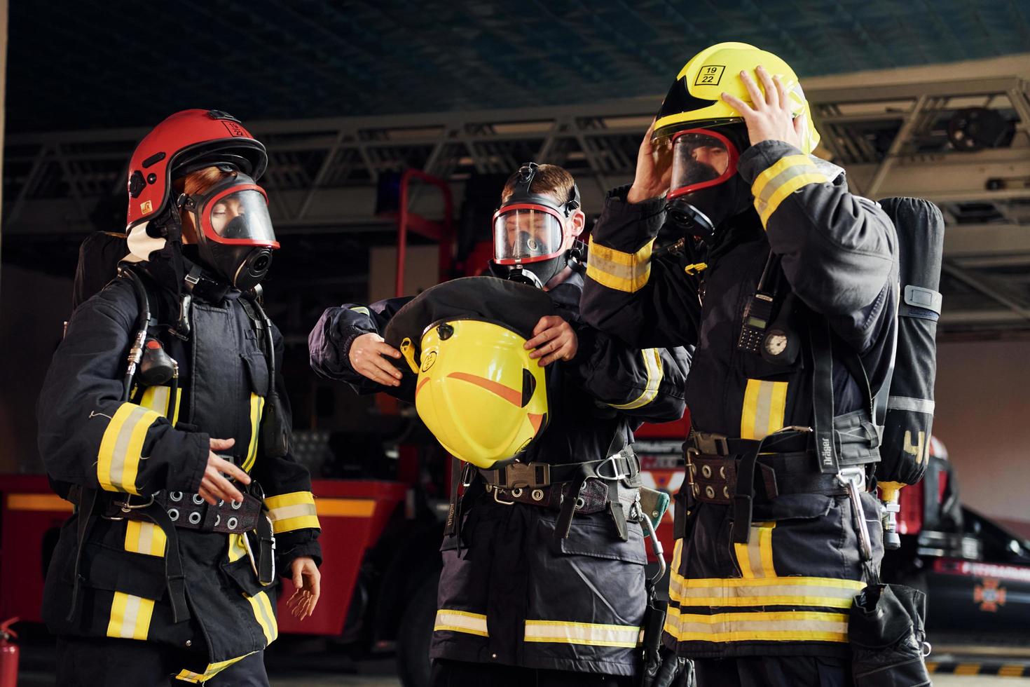 vistiendo uniforme de protección. grupo de bomberos que está en la estación foto