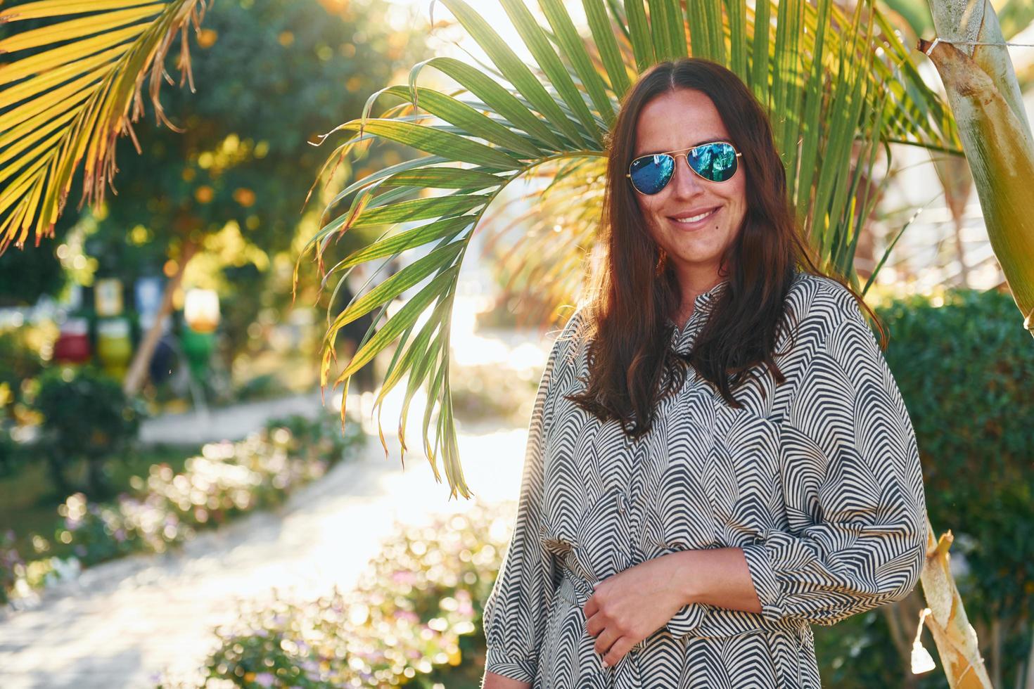 Happy mature woman is outdoors enjoying her vacation at sunny daytime photo