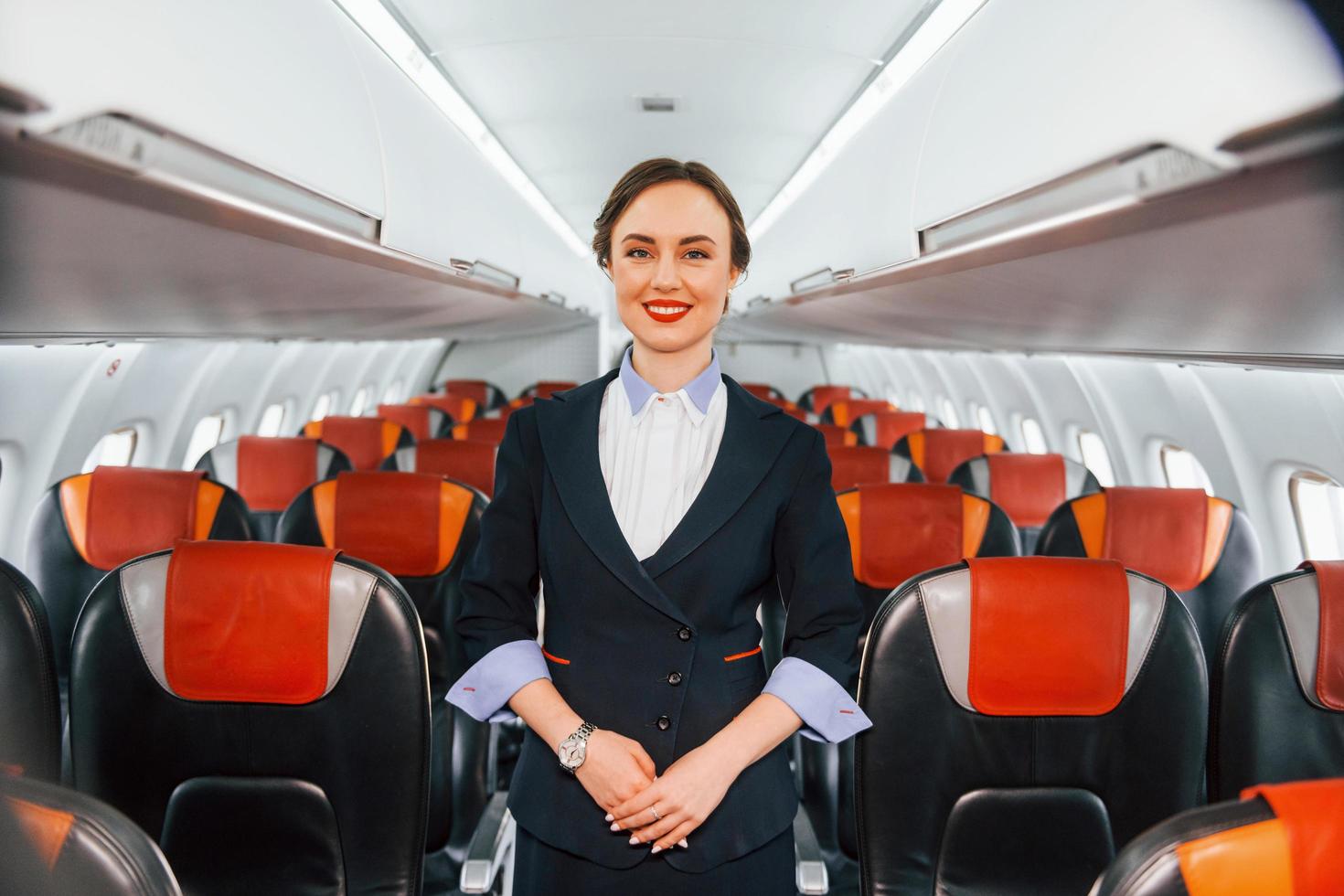 Asientos vacíos. joven azafata en el trabajo en el avión de pasajeros foto