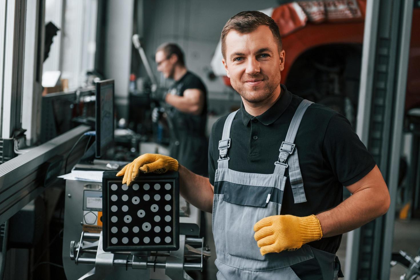 trabajo en progreso. el hombre de uniforme está en el servicio de automóviles foto