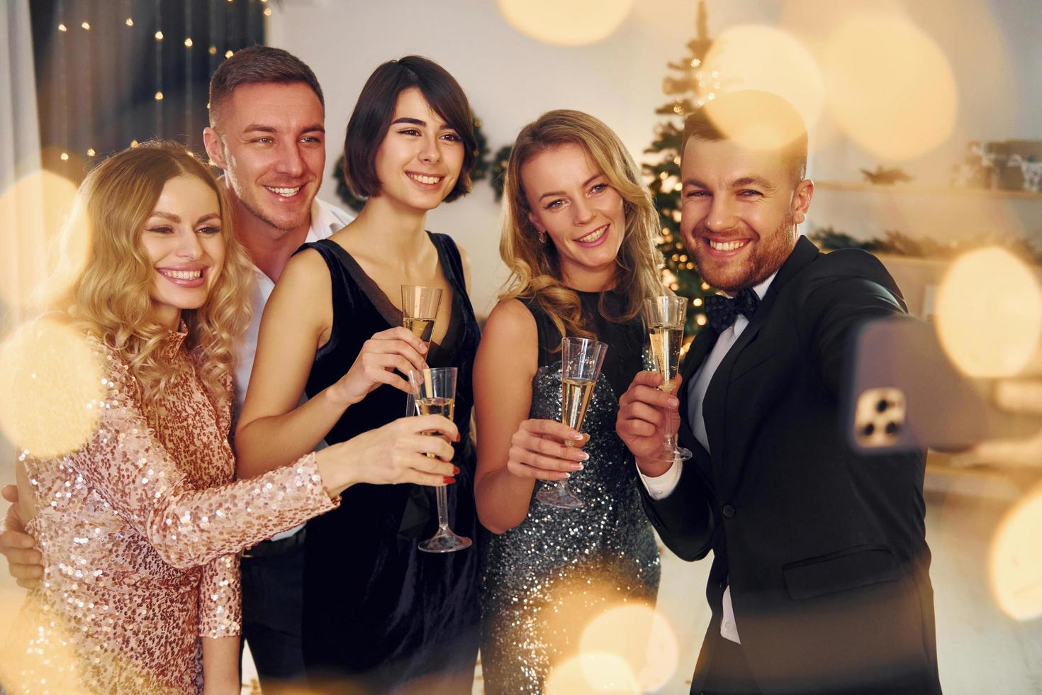 haciendo selfie grupo de personas tienen una fiesta de año nuevo en el interior juntos foto