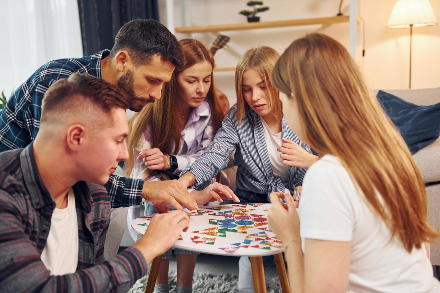 Playing smart game. Group of friends have party indoors together photo