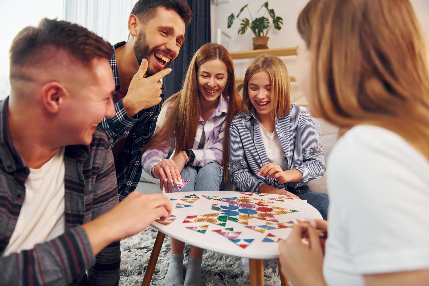 Playing smart game. Group of friends have party indoors together photo