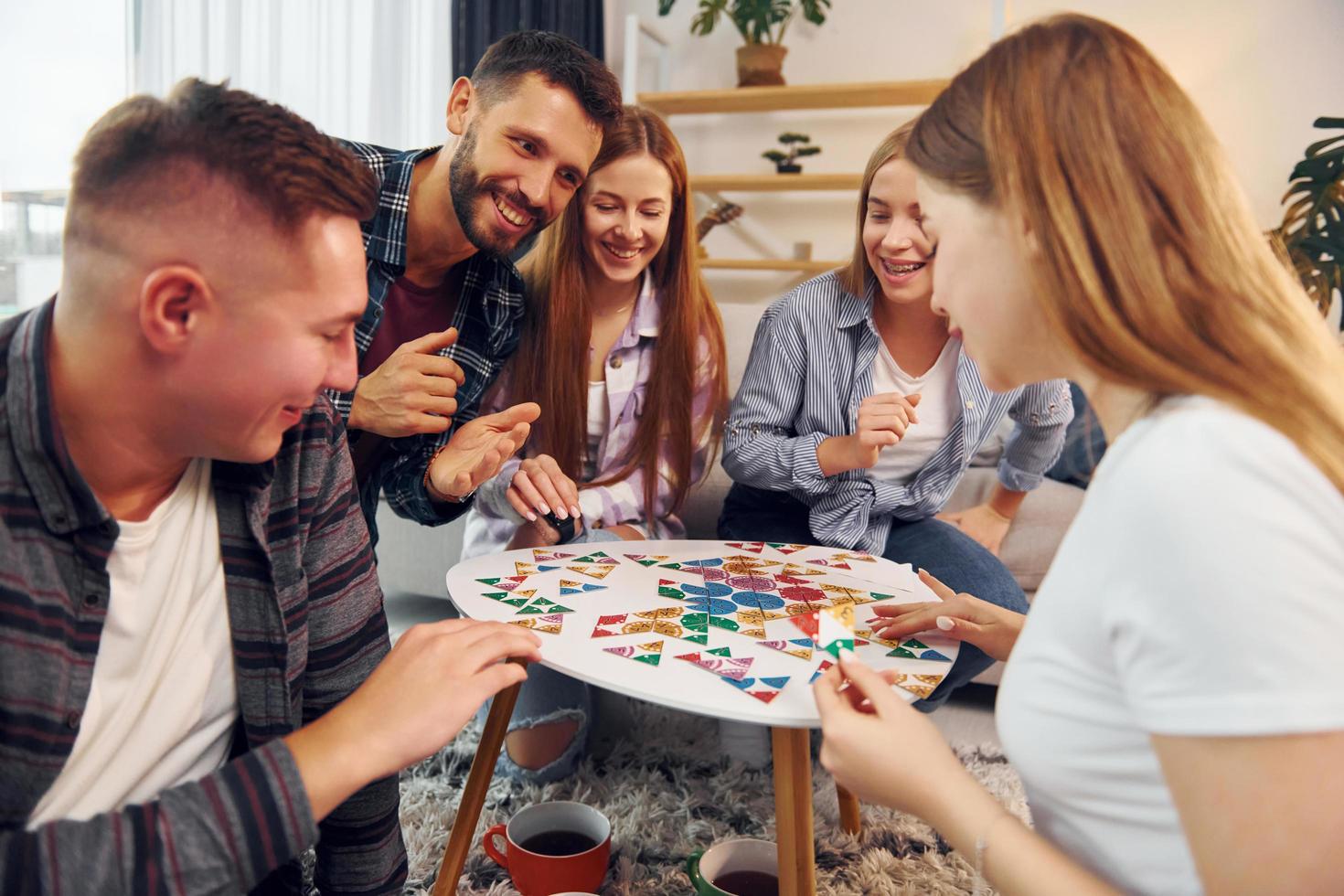 jugando un juego inteligente. grupo de amigos tienen una fiesta en el interior juntos foto