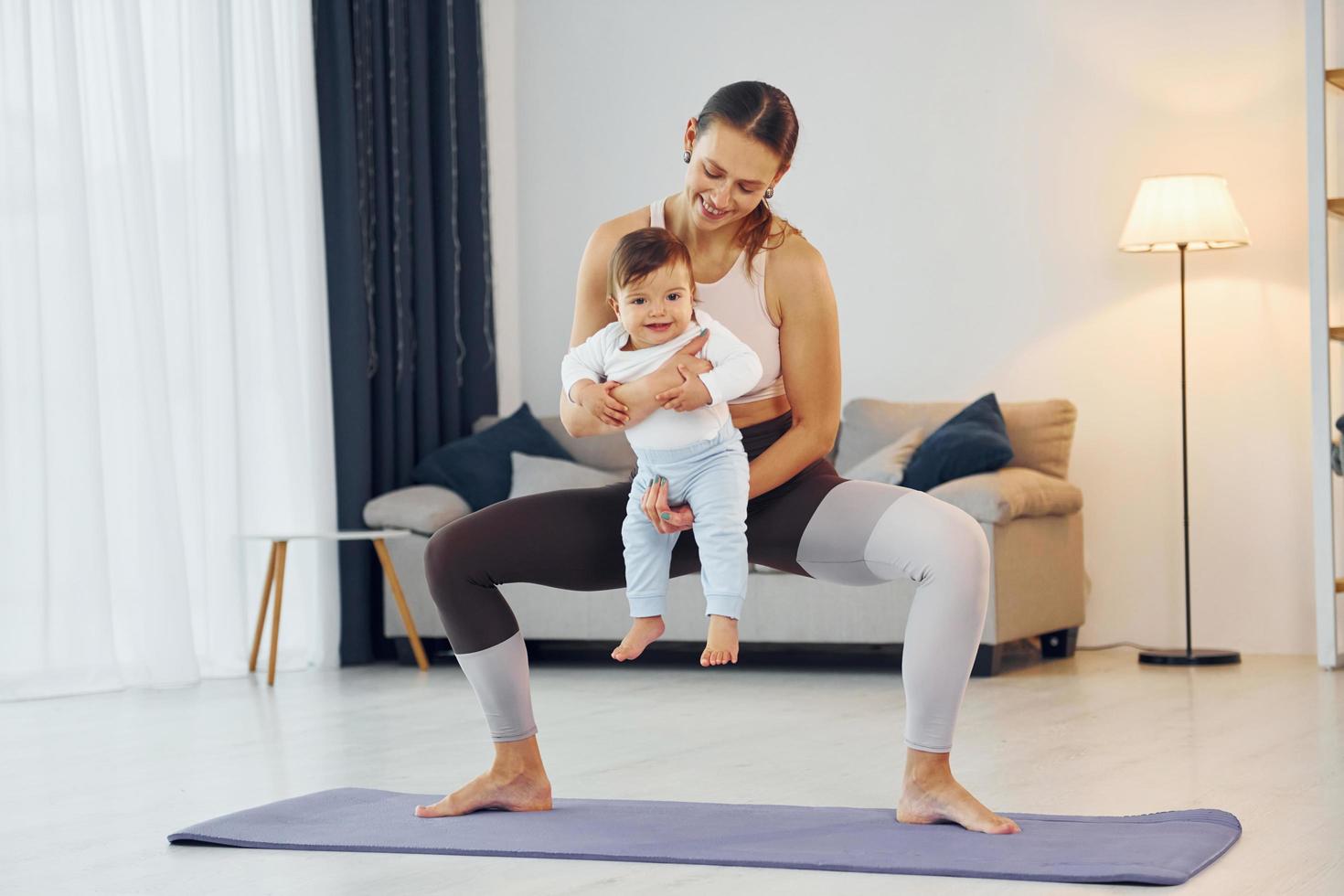 Teaching fitness. Mother with her little daughter is at home together photo