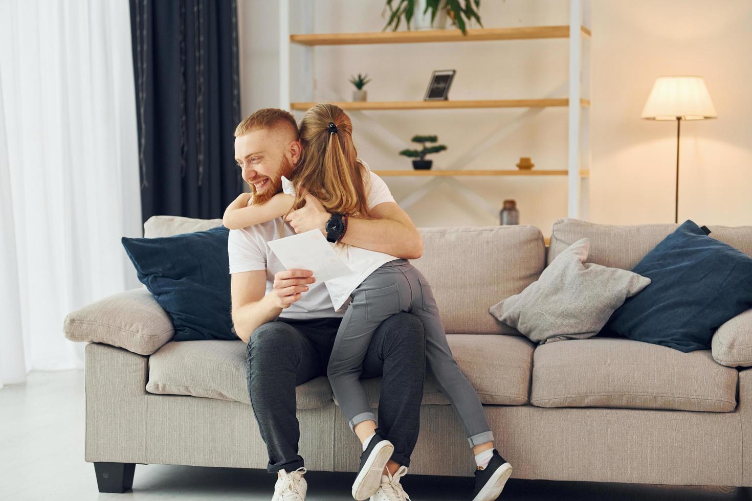 con caja de regalo. padre con su pequeña hija está en casa juntos foto