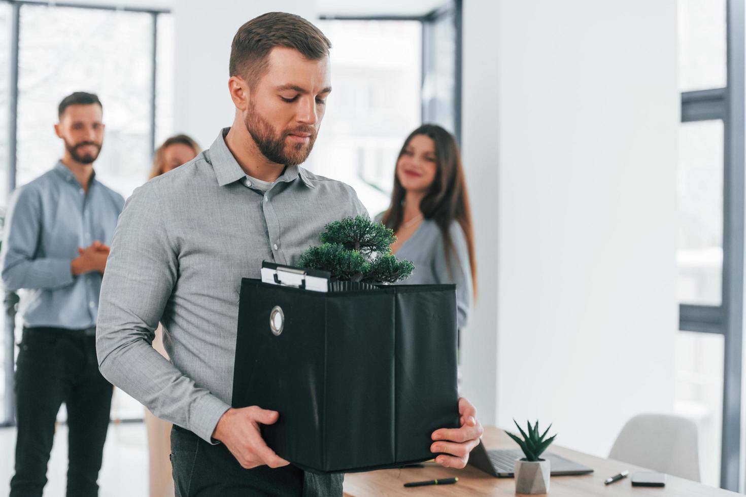 Man holding package. Group of business people that working on the project in the office photo