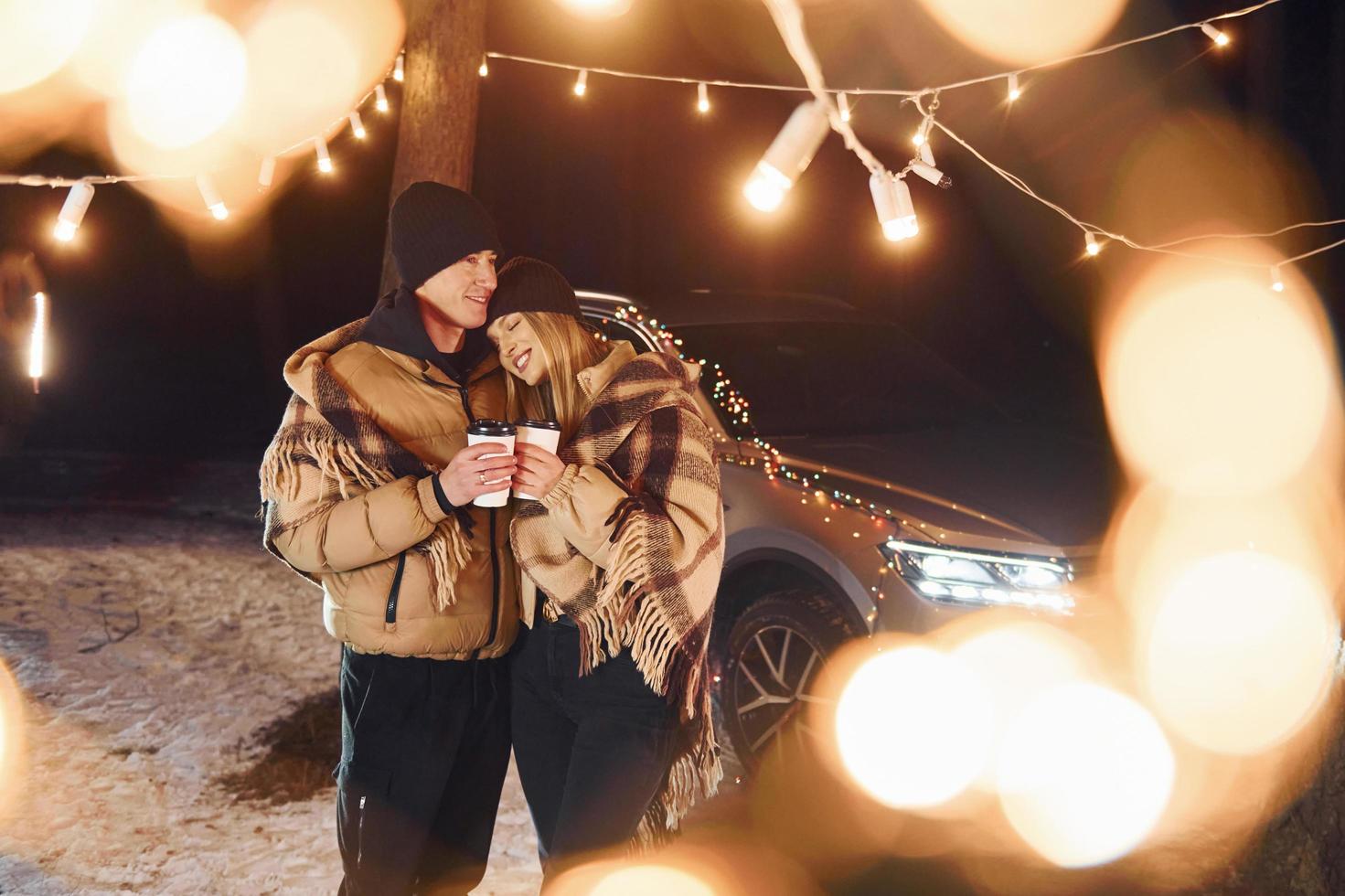 Having a walk. Couple standing in the forest and celebrating New year photo