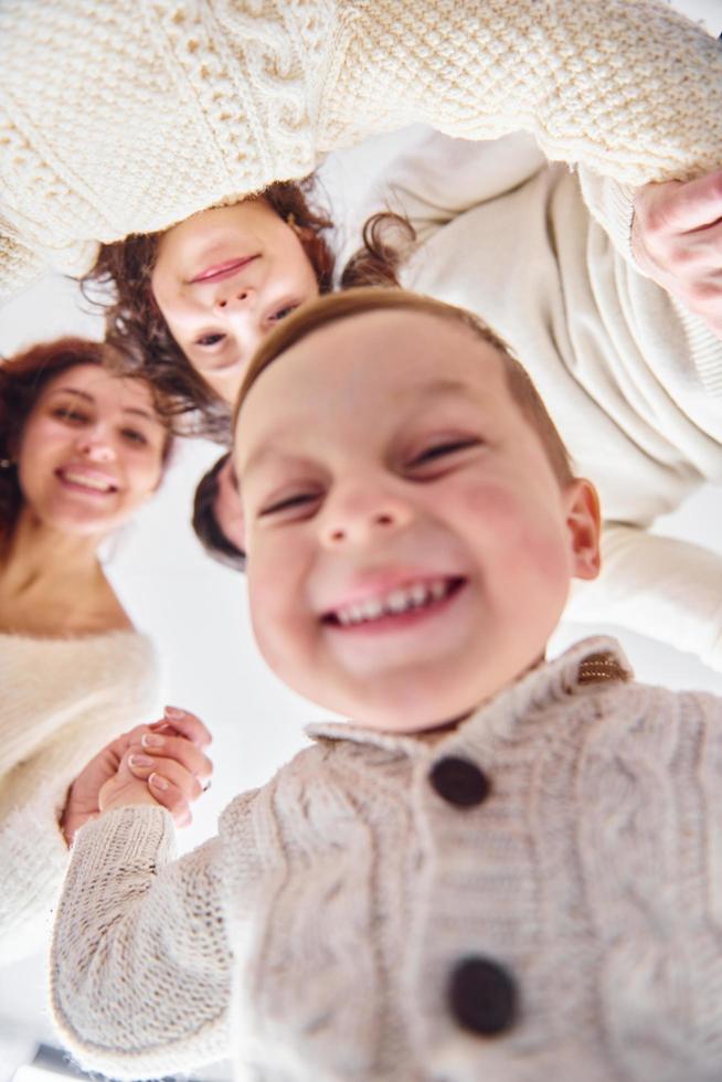 sonriendo y divirtiéndose. vista desde abajo. familia feliz mirando hacia abajo foto