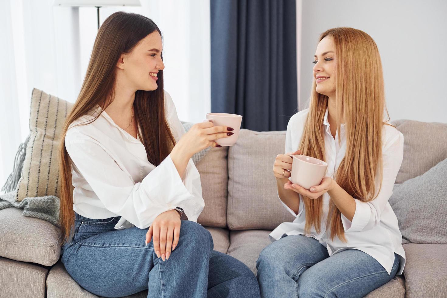 hablando uno al otro. la joven madre con su hija está en casa durante el día foto