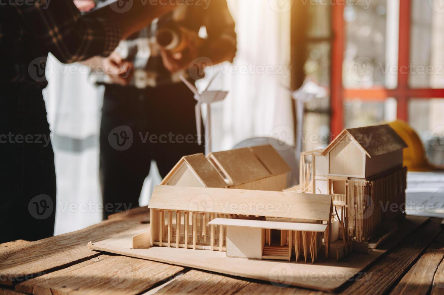 arquitecto de equipo profesional, ingeniero o plano de revisión de interiores en el escritorio del lugar de trabajo detrás del modelo de la casa en la oficina foto