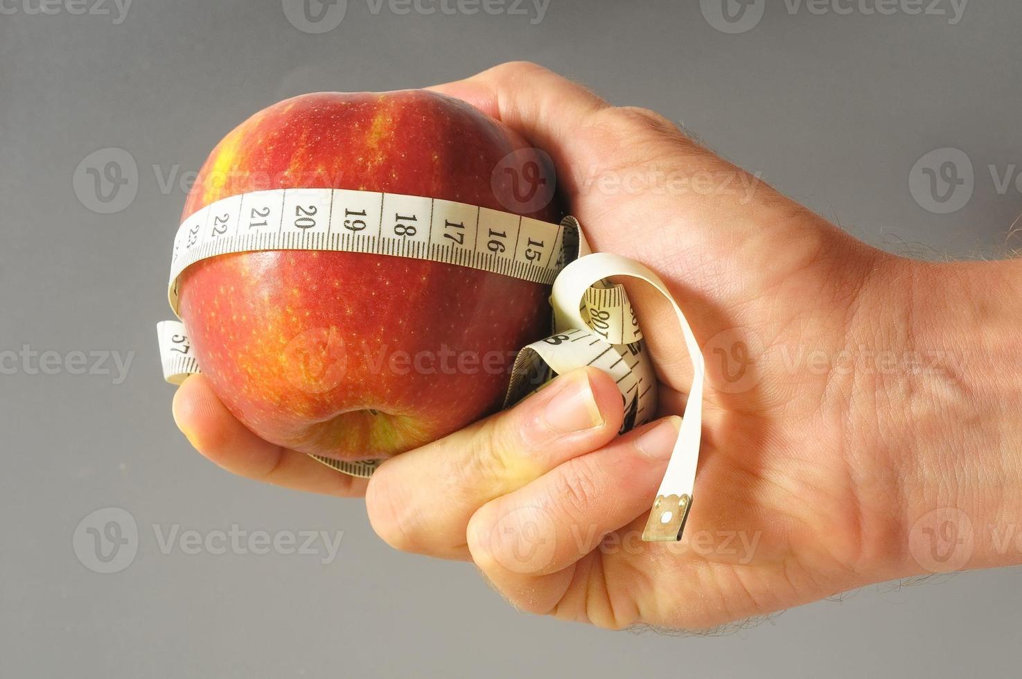 manzana dietética y medidor en la mano foto