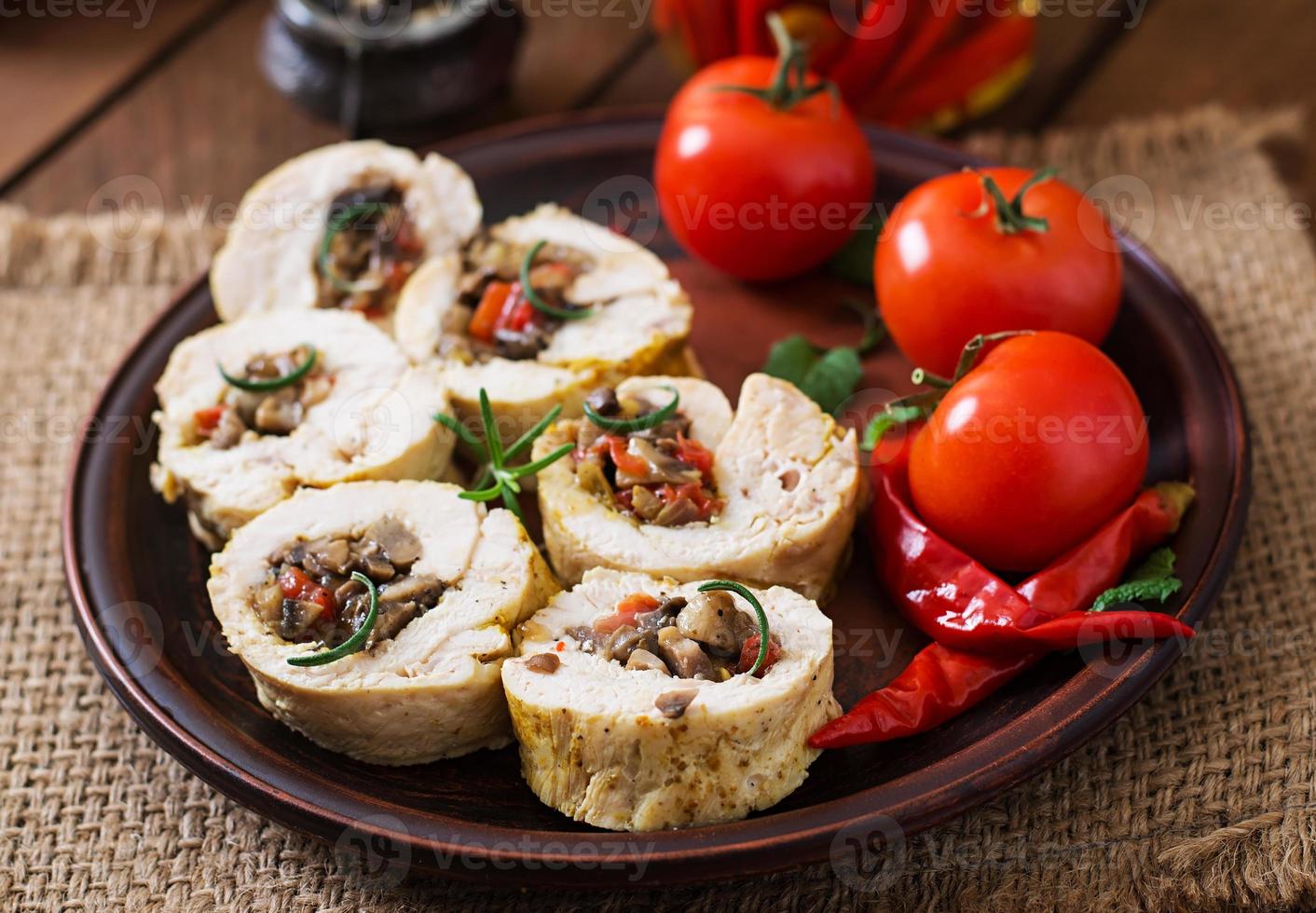Baked chicken rolls with mushrooms and paprika on brown plate photo