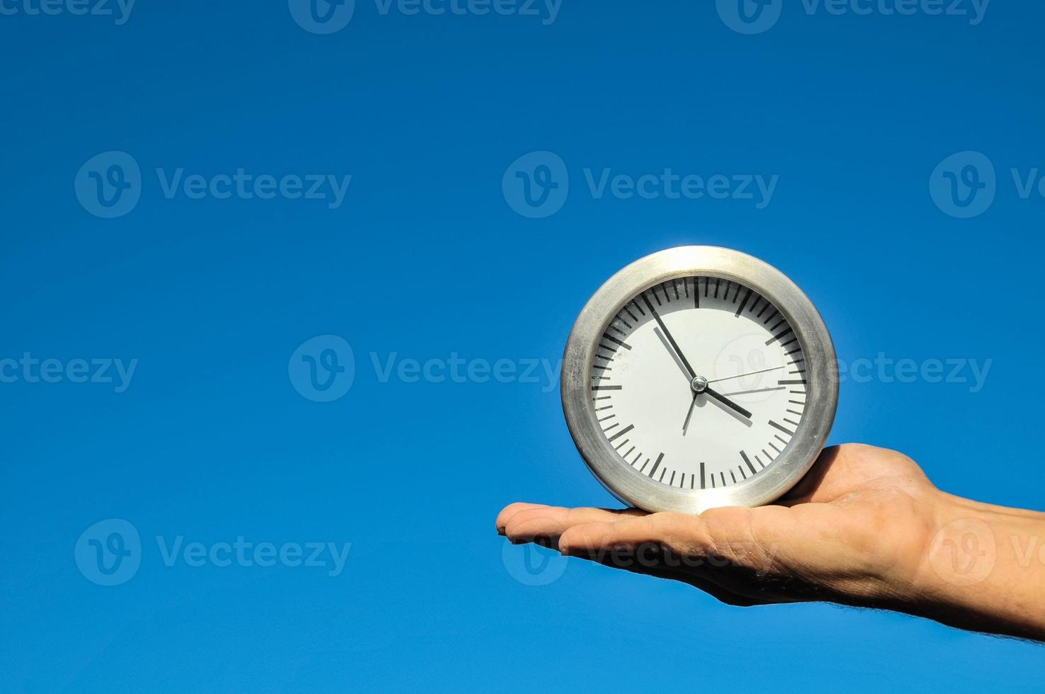 Time Concept with hand holding a clock photo