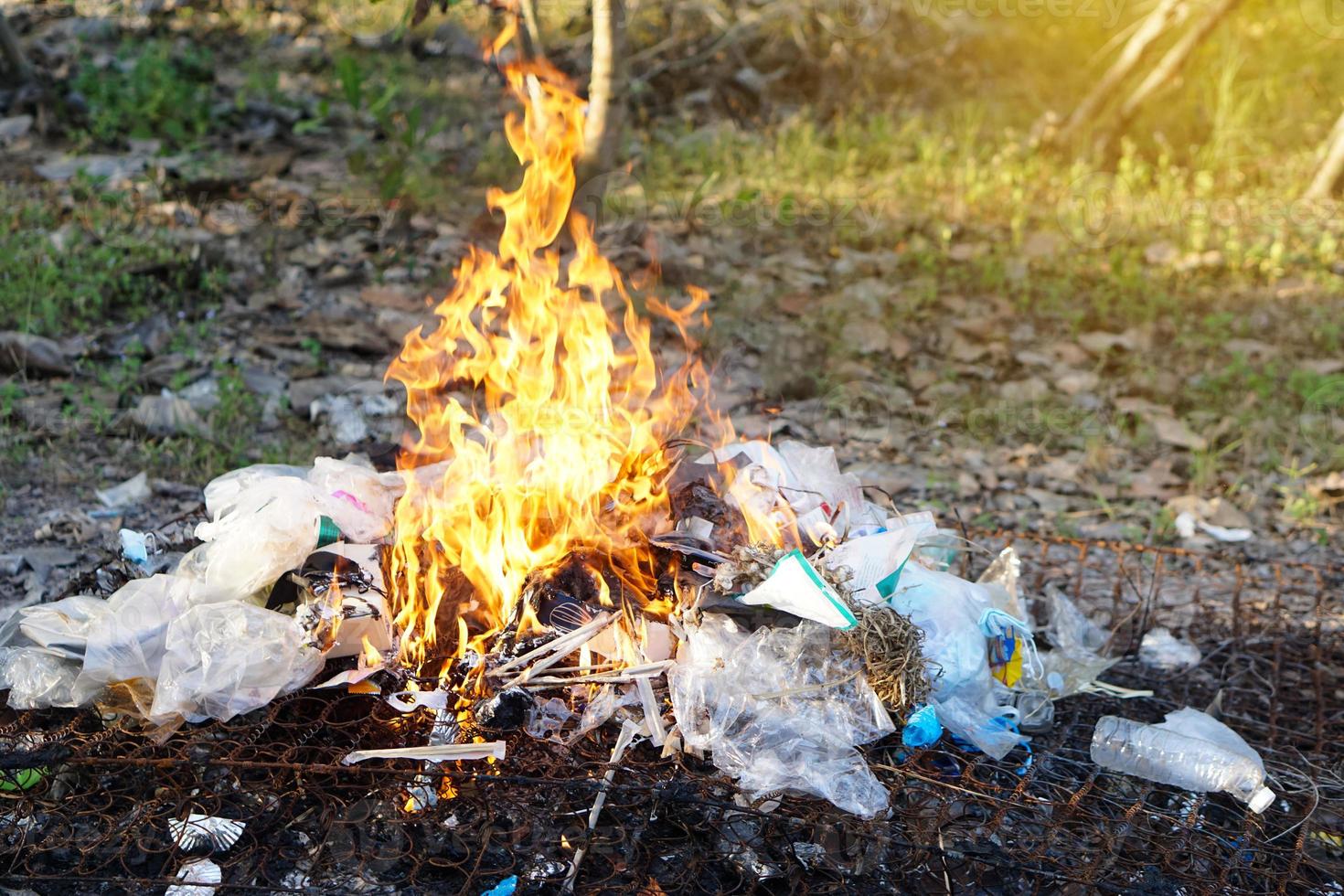 Fire burning pile of garbage. Concept, Incineration of household waste, paper, cardboard, food scraps, plastic, twigs and other waste that causes air pollution. Trash management photo