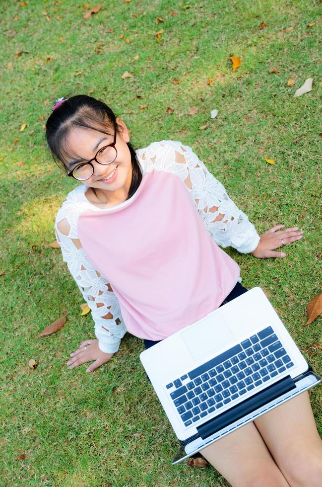 Cute girl is happy with notebook on grass photo