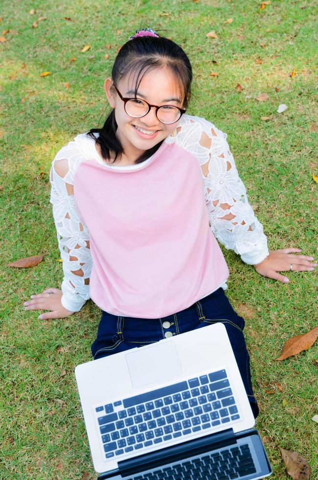 Cute girl is happy with notebook on grass photo