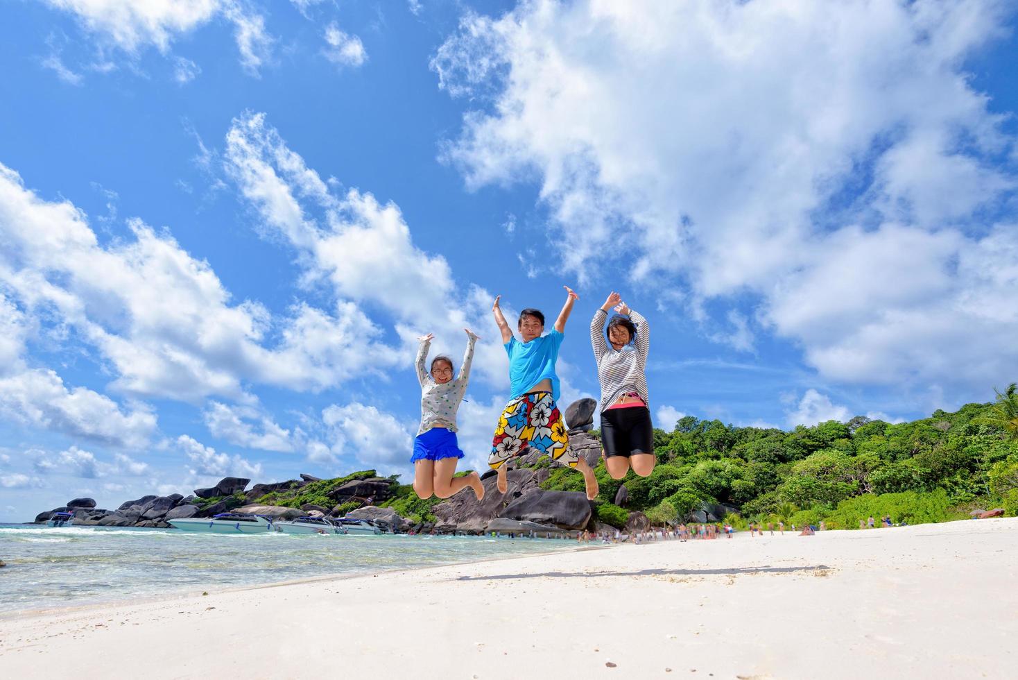 Happy family jumping on beach in Thailand photo