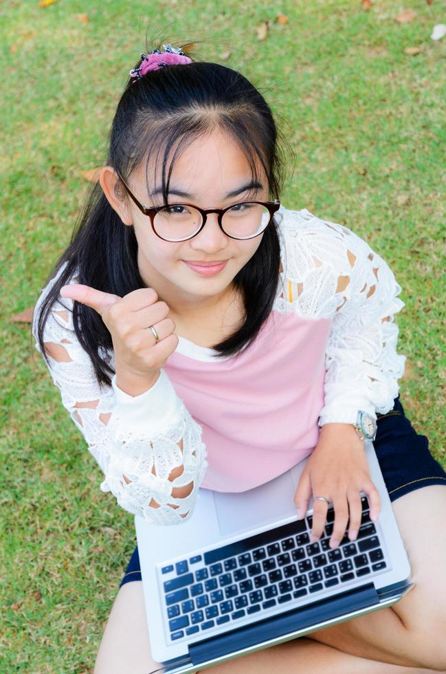 Lovely girl with a laptop on the grass photo