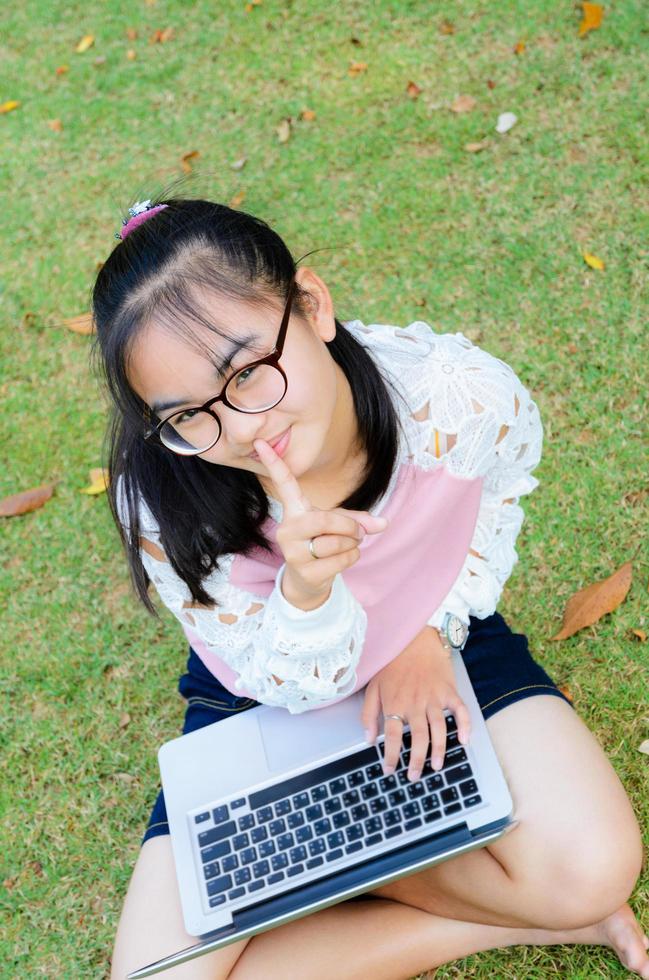 Lovely girl with a laptop on the grass photo