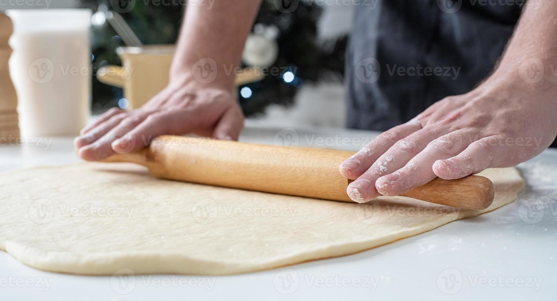 chef masculino trabajando con masa, cocinando rollos de canela foto