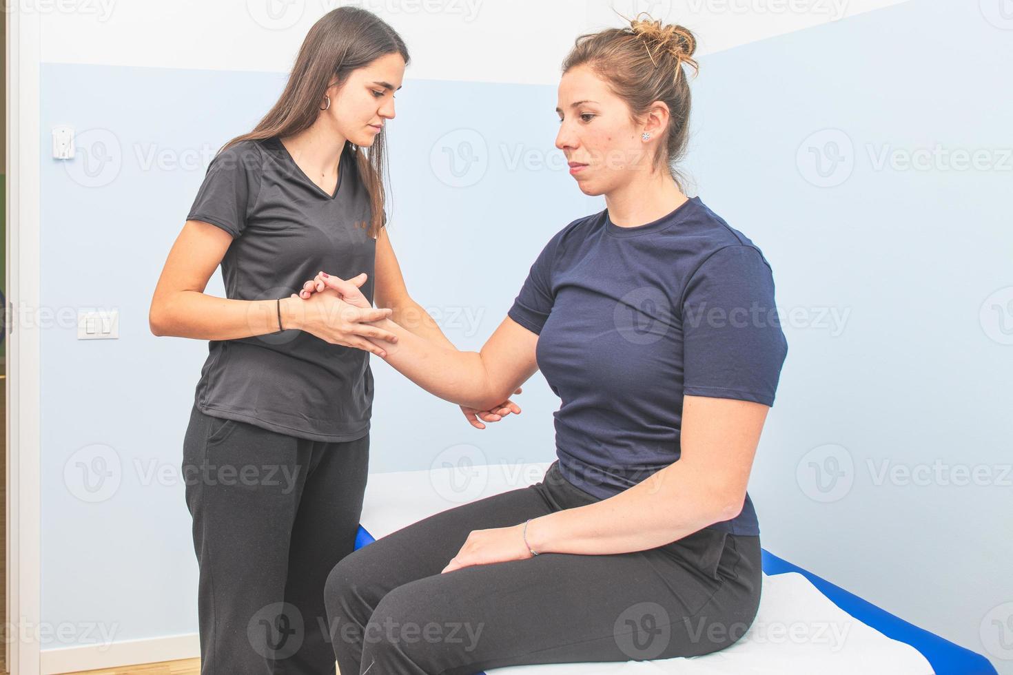 A physical therapist performs shoulder elbow evaluation photo