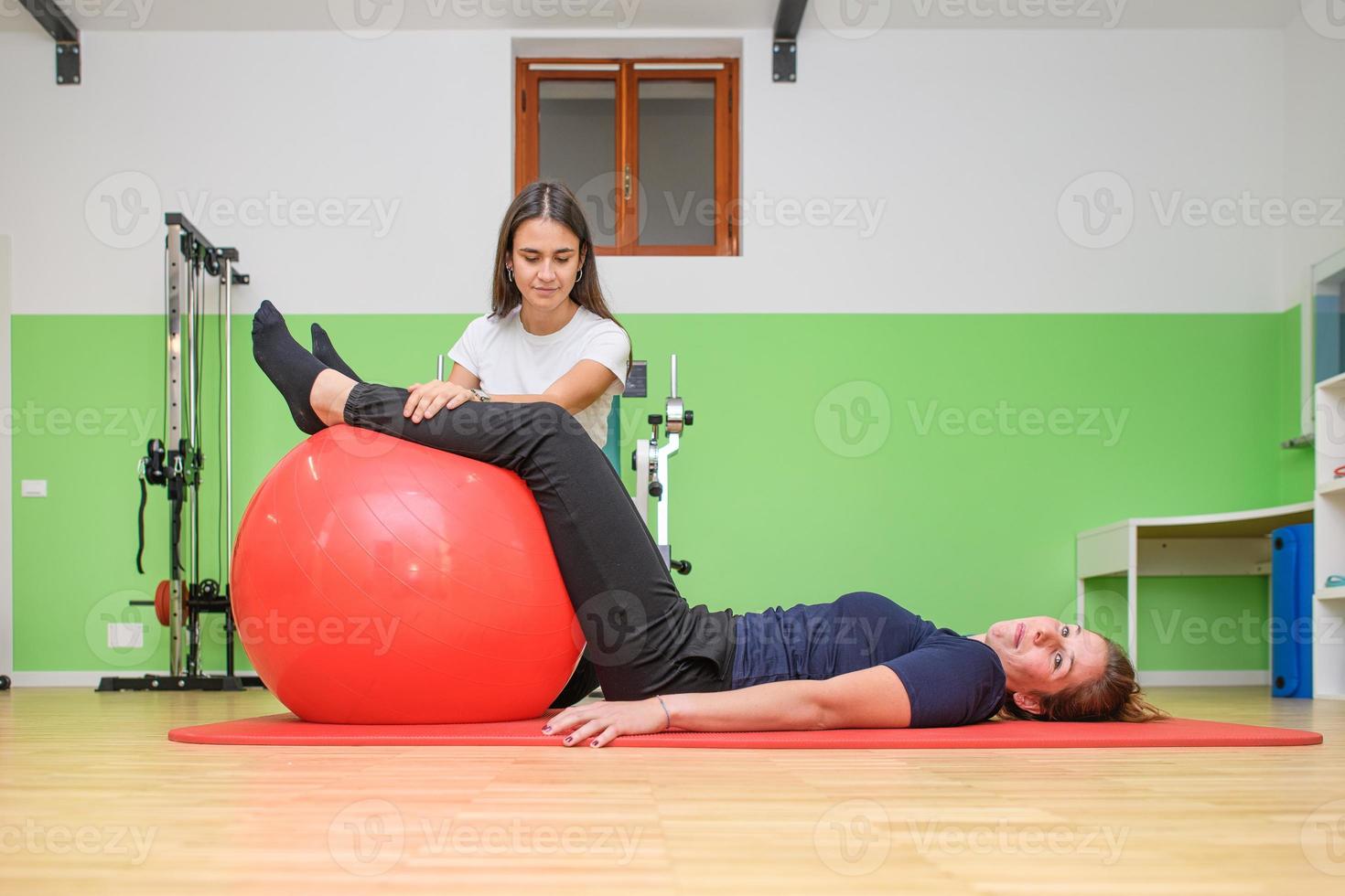 A physical therapist perform an exercise of muscle toning with the fitball.jpg photo