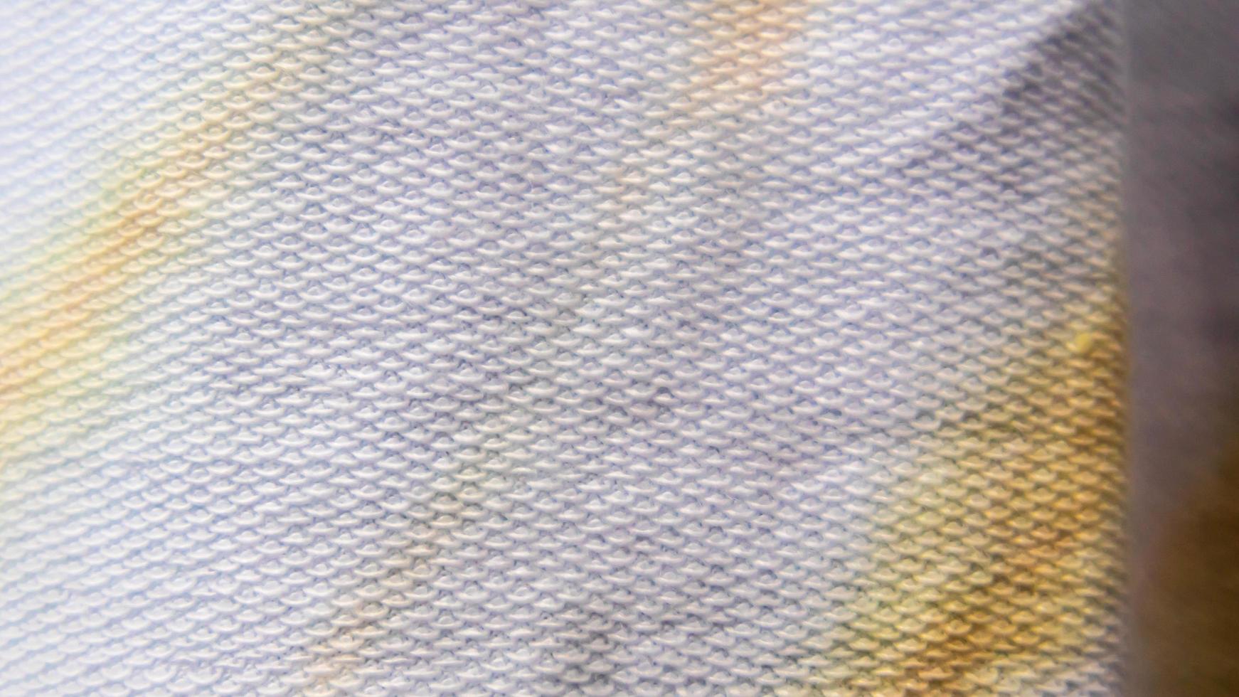 white cloth texture with yellow and blue patterns as background photo