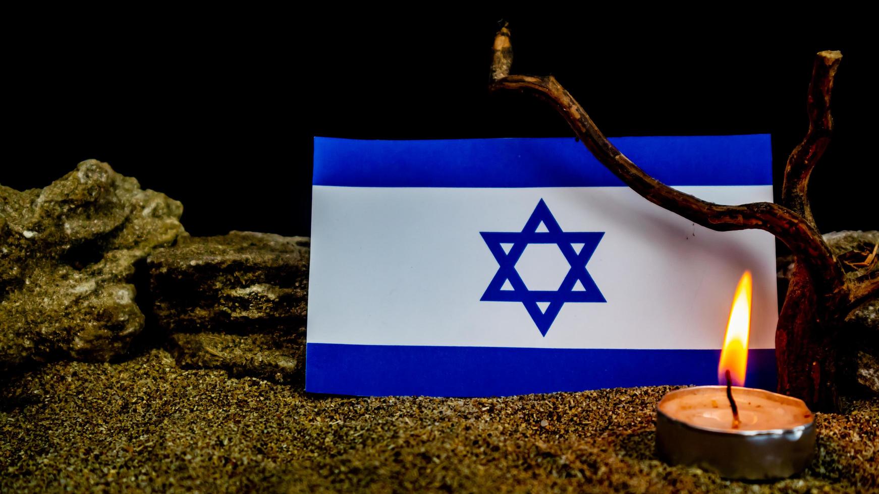 Israeli flag and candles burning in front of it, Holocaust memory day photo