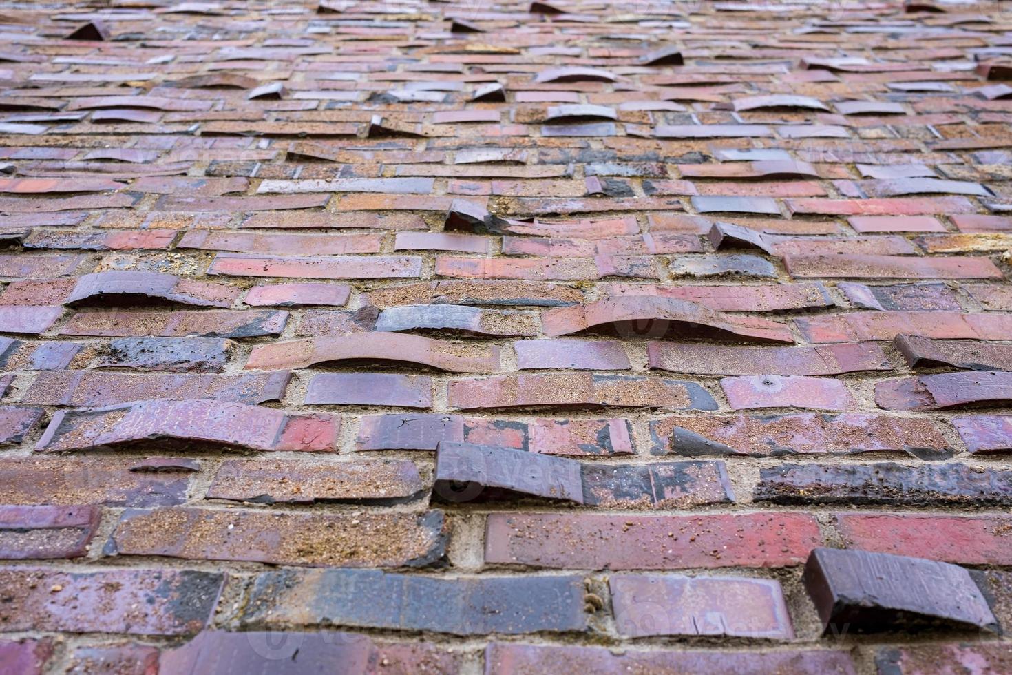 Old uneven brick wall, with protruding bricks. Bottom view. Copy space
