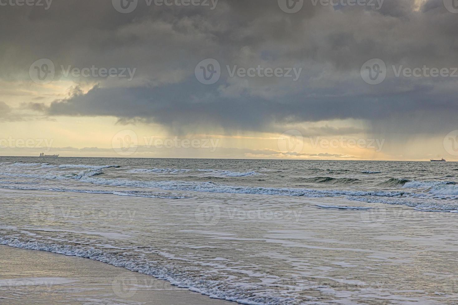 Picture of transport ship on stormy sea photographed from a beach photo