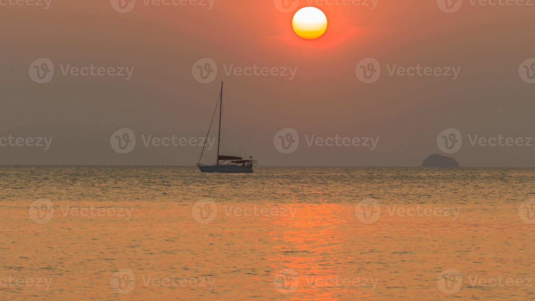 Sunset over the sea with boat silhouette photo