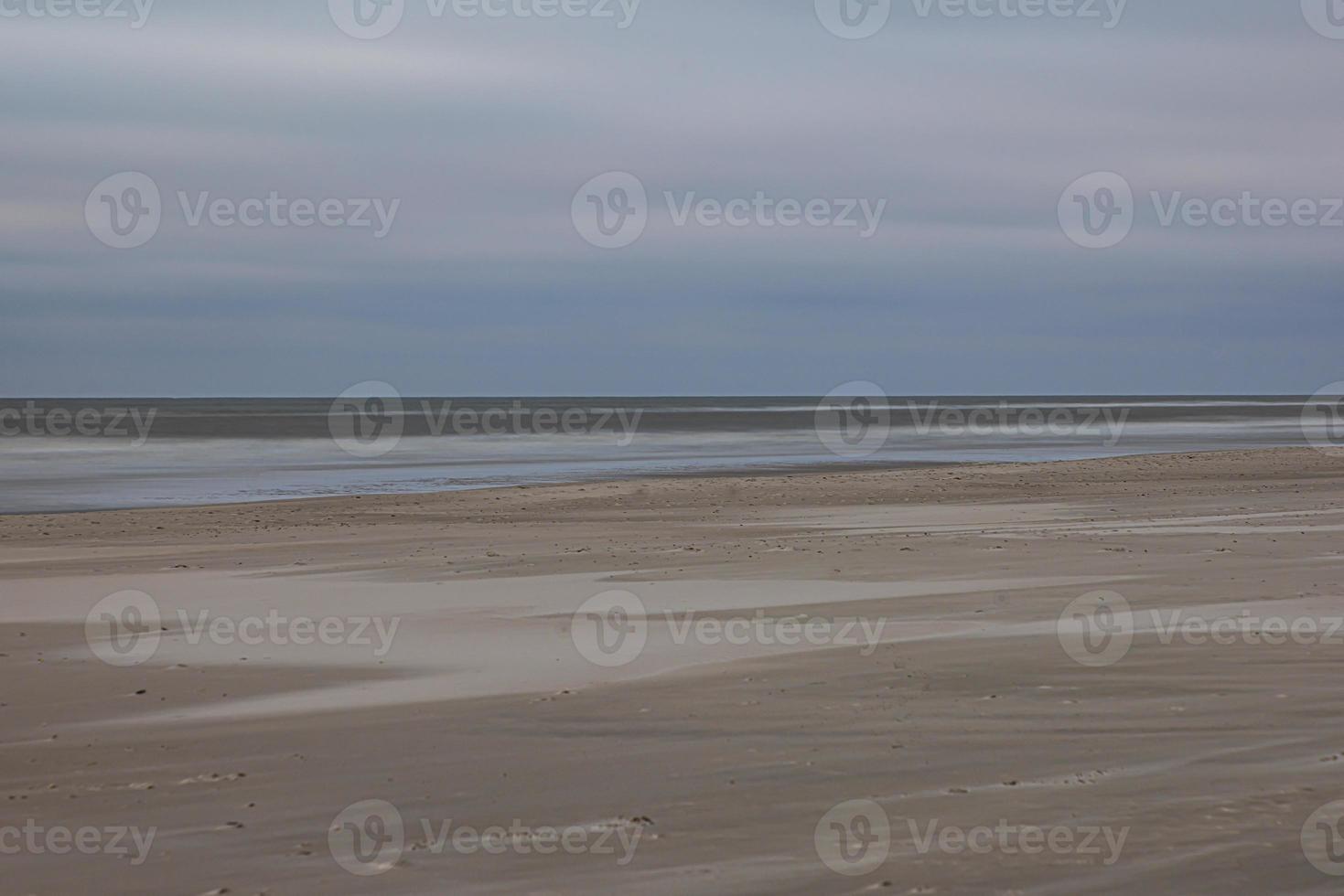 View of wide sandy beach of Vejers in Denmark in evening light photo