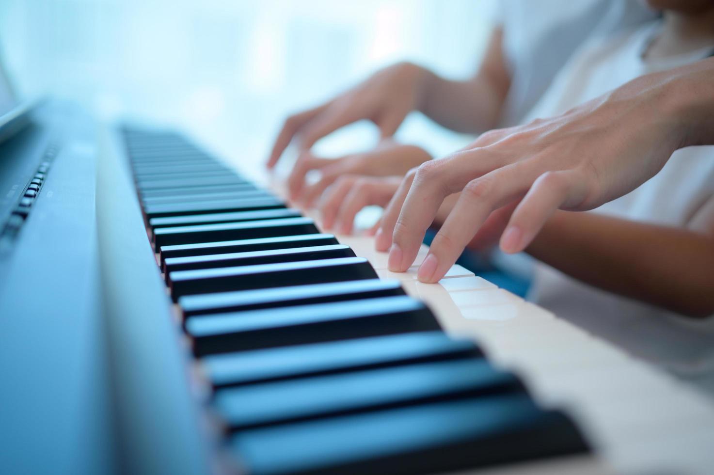 Family vacation, father and mother helping daughter practice in her piano lessons photo