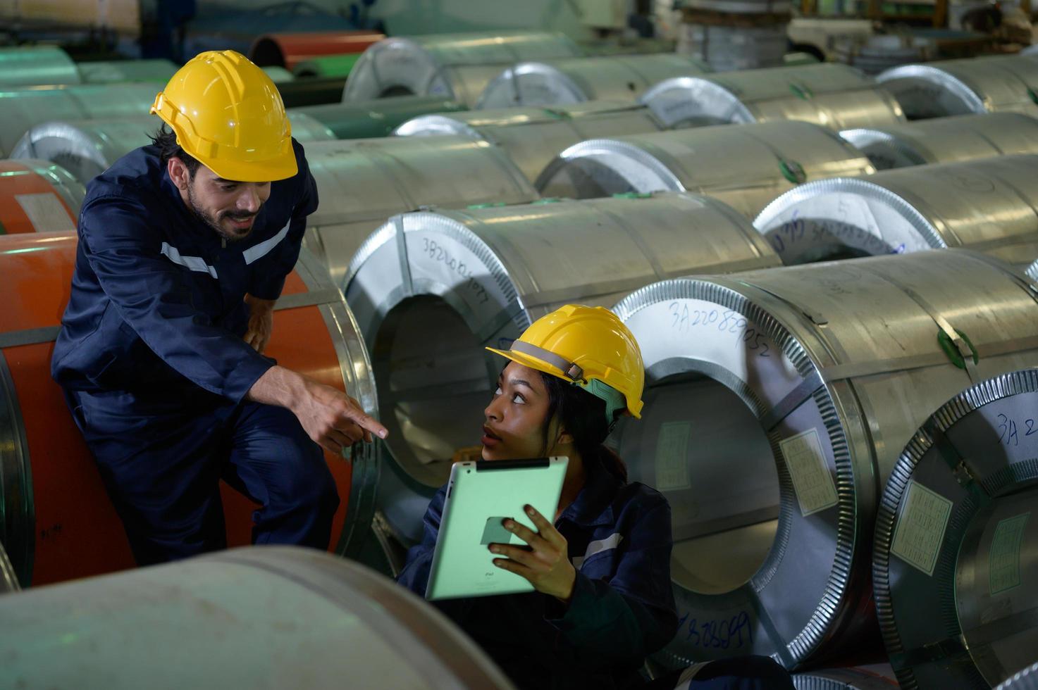 Young female engineer learning to run machinery at a factory with veteran engineers photo