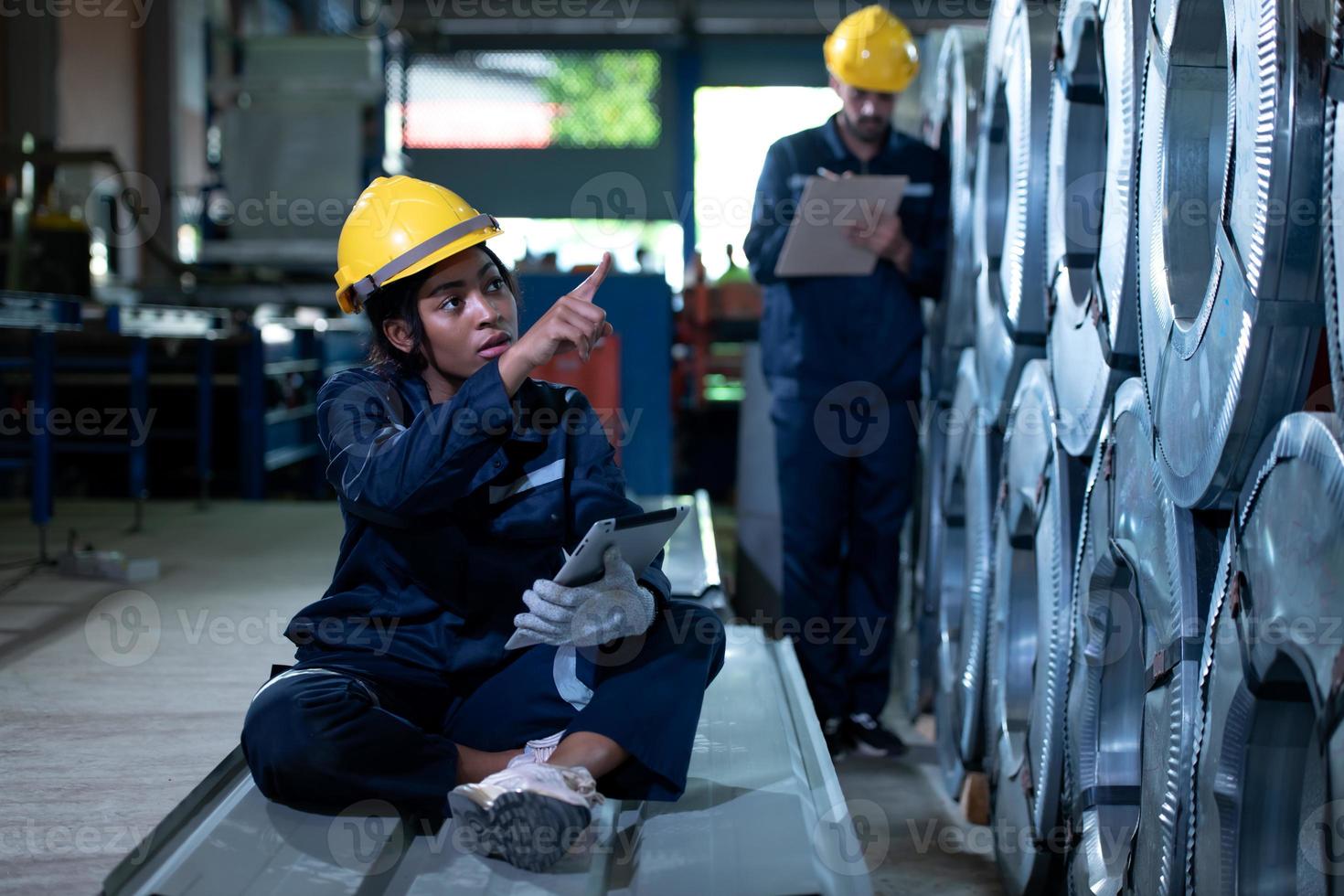Young female engineer learning to run machinery at a factory with veteran engineers photo