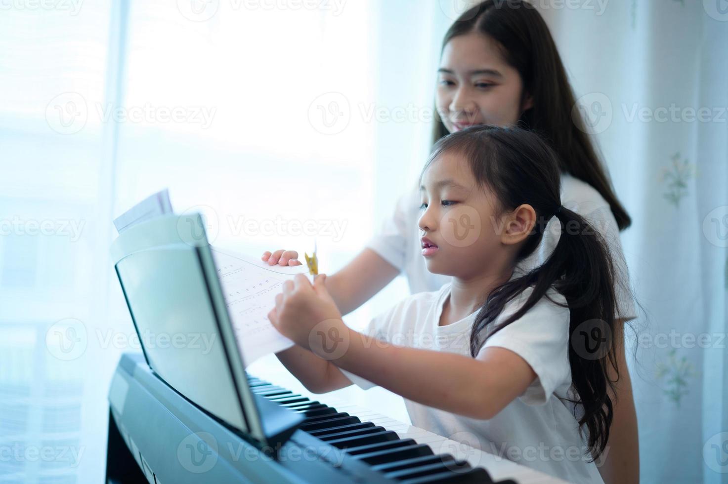 Family vacation, other helping daughter practice in her piano lessons photo