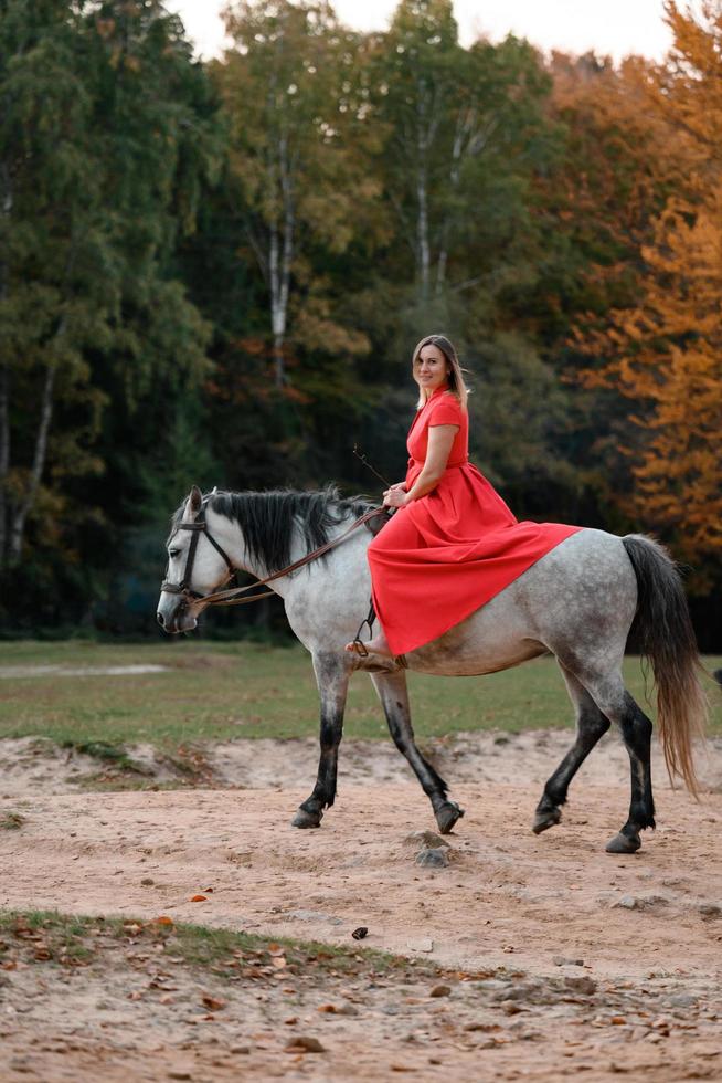 Riding a horse, walking in an autumn forest, a woman riding a horse in