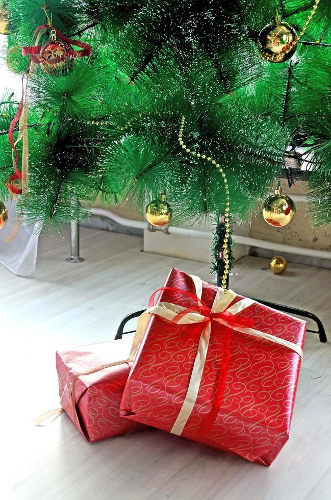 Wrapped present boxes closeup and beautiful decorated christmas tree with ornaments photo