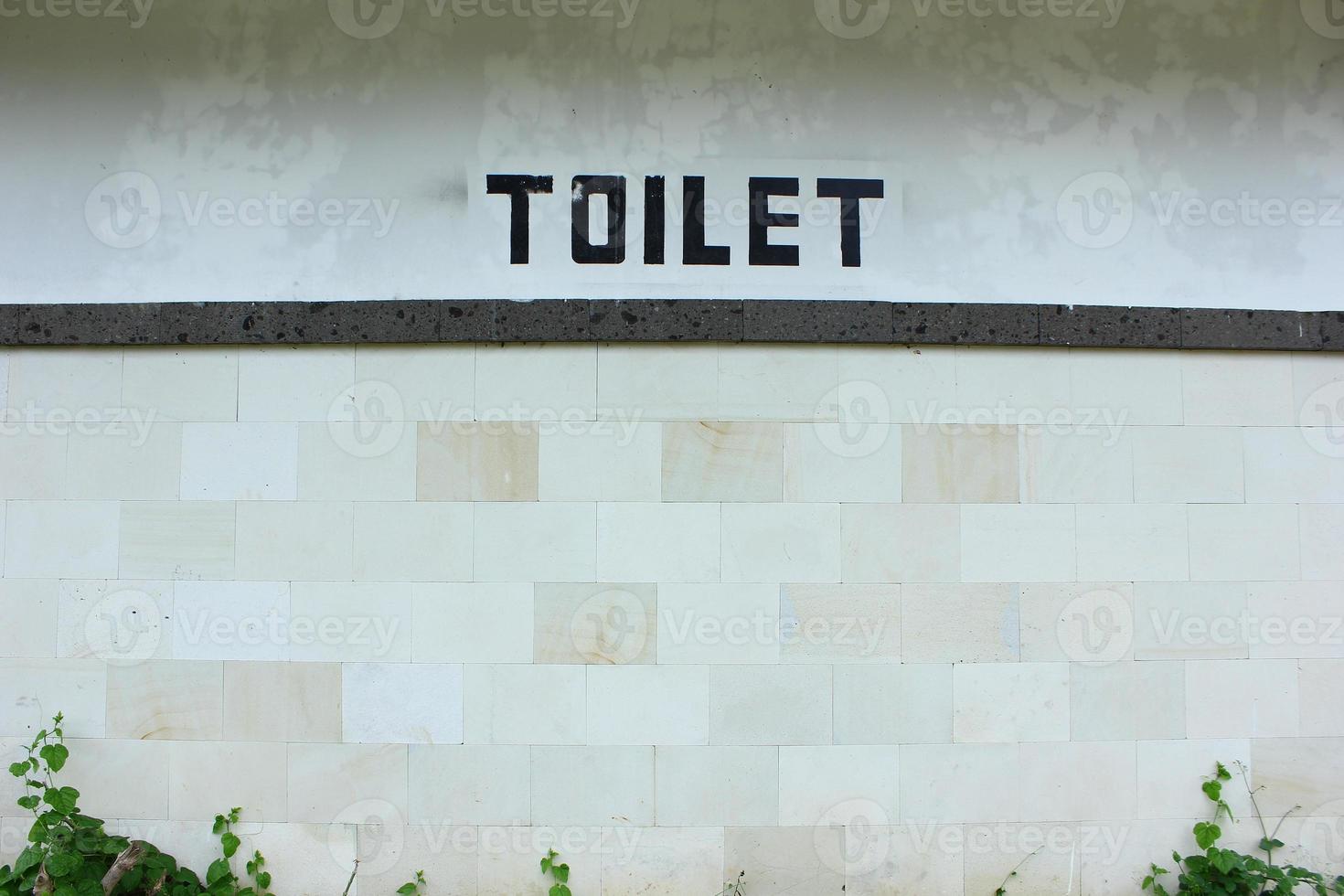 una inscripción de baño en una pared blanca con una textura geométrica y se ve muy estética. foto