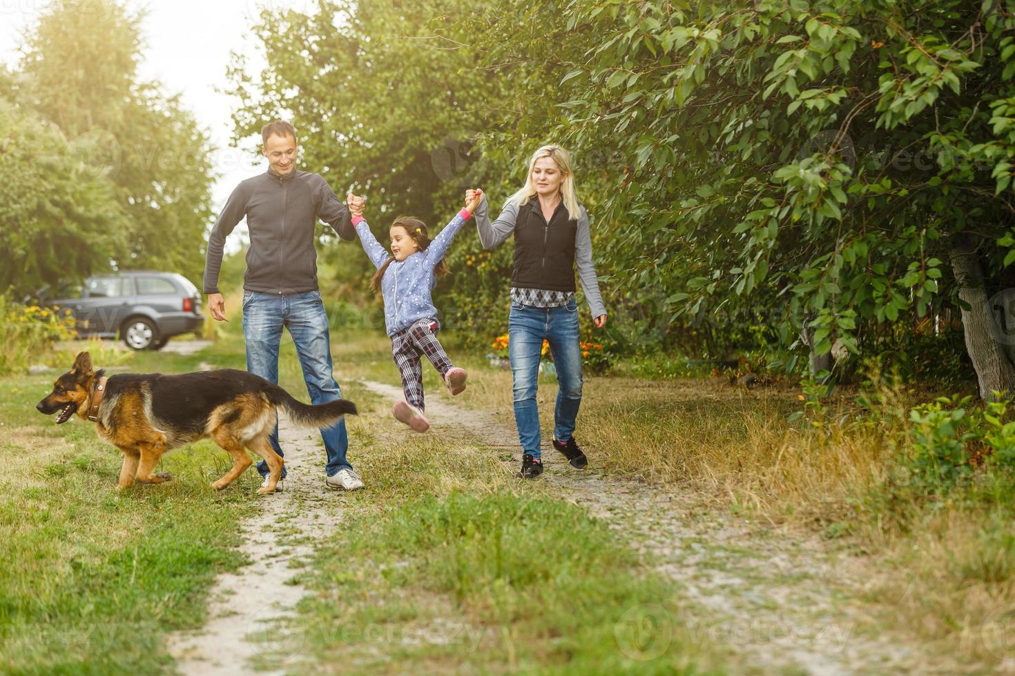 Happy children and parents with dog as family running in the nature photo