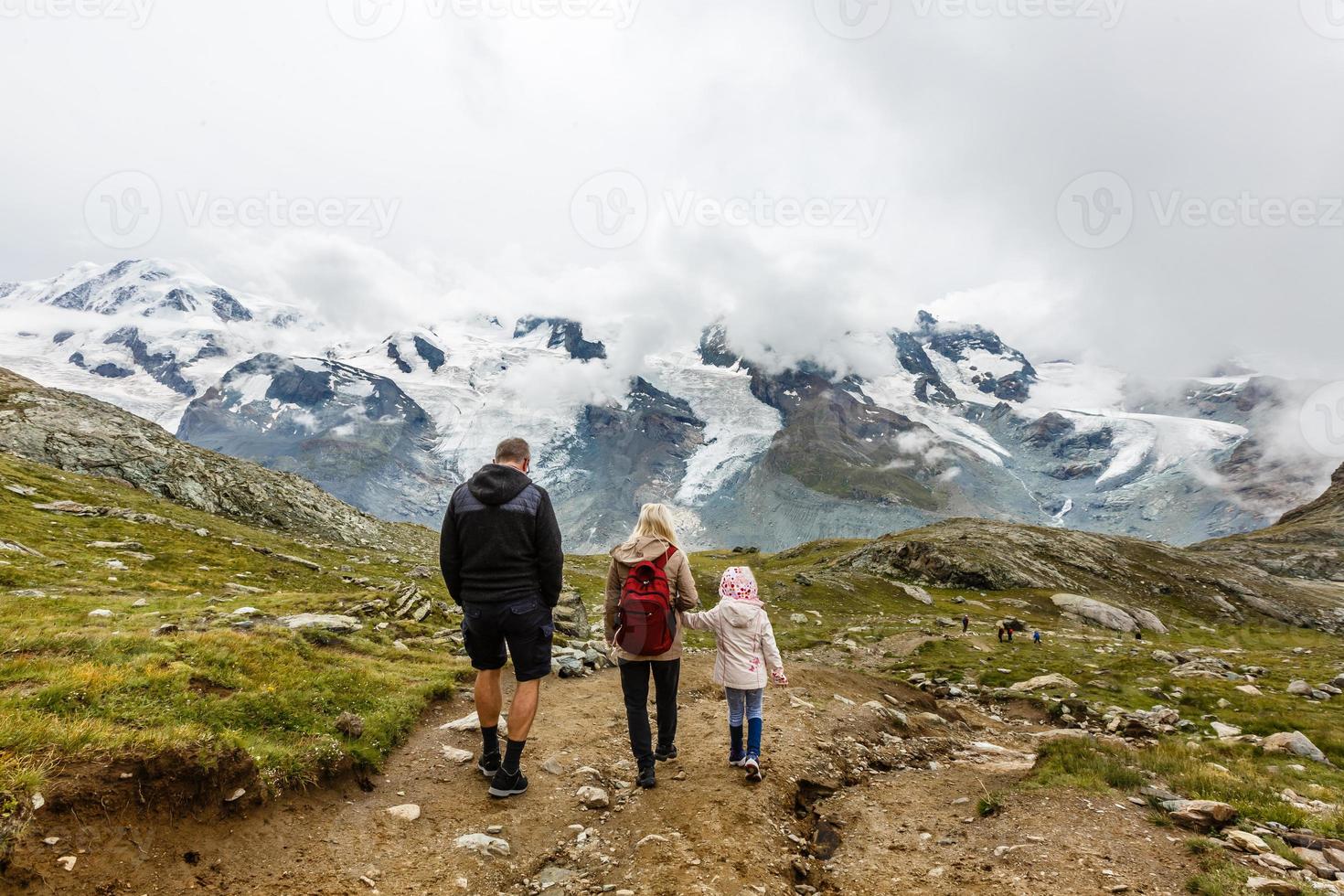 madre e hijos paseando por un entorno montañoso foto