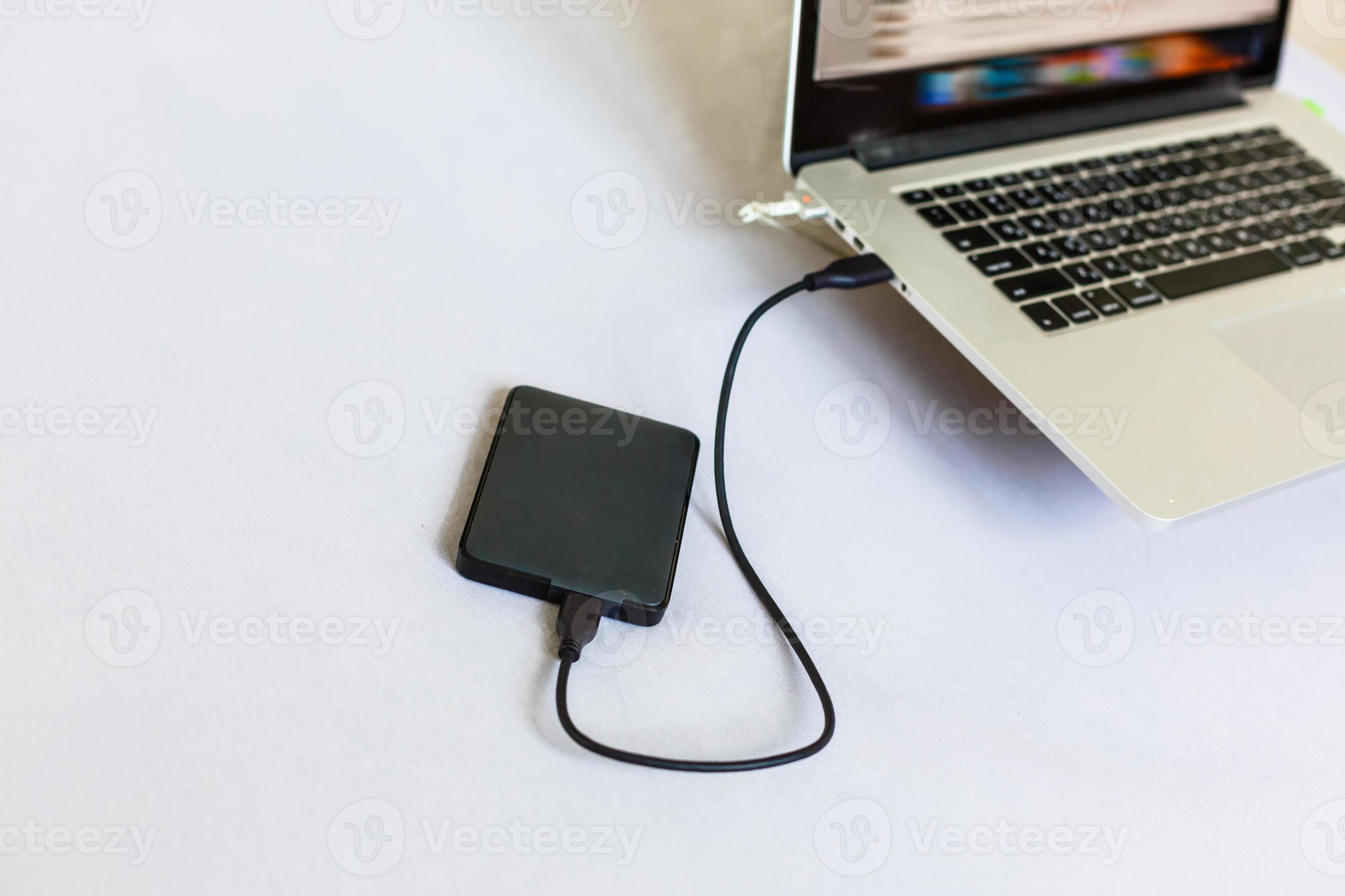 Black external hard disk connecting to a laptop 16749149 Stock Photo at