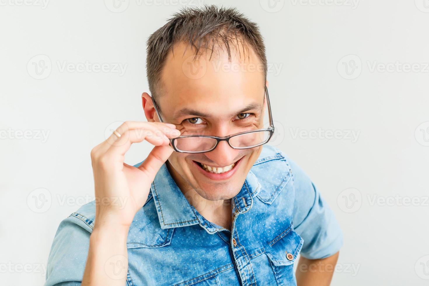 un hombre tonto con gafas nerd de moda aislado sobre blanco con una expresión divertida en su rostro. foto