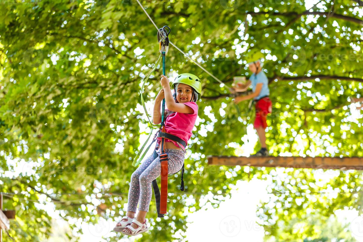 happy little children in a rope park on the wood background photo