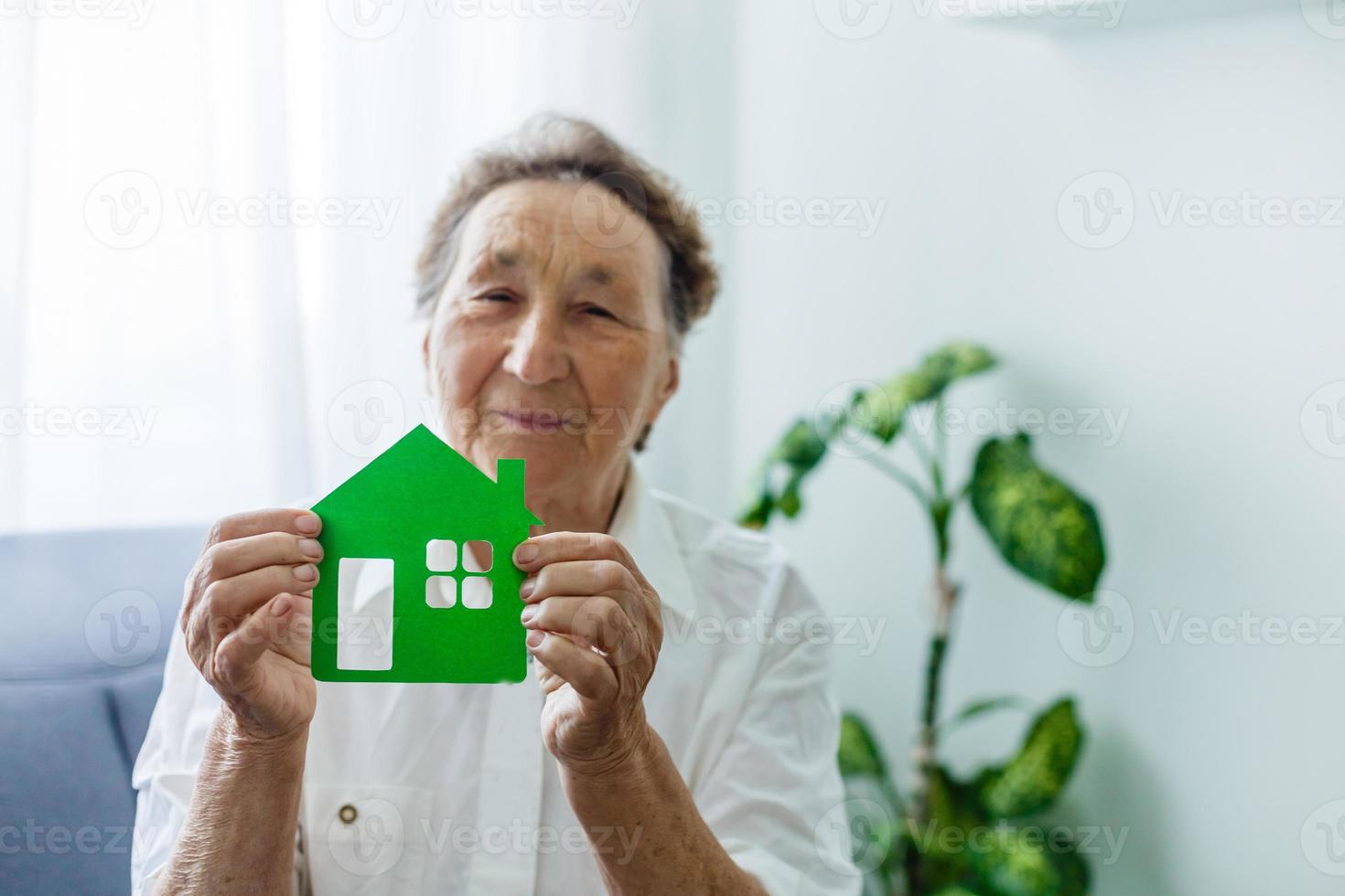 mujer mayor tiene el diseño de la casa en sus manos foto