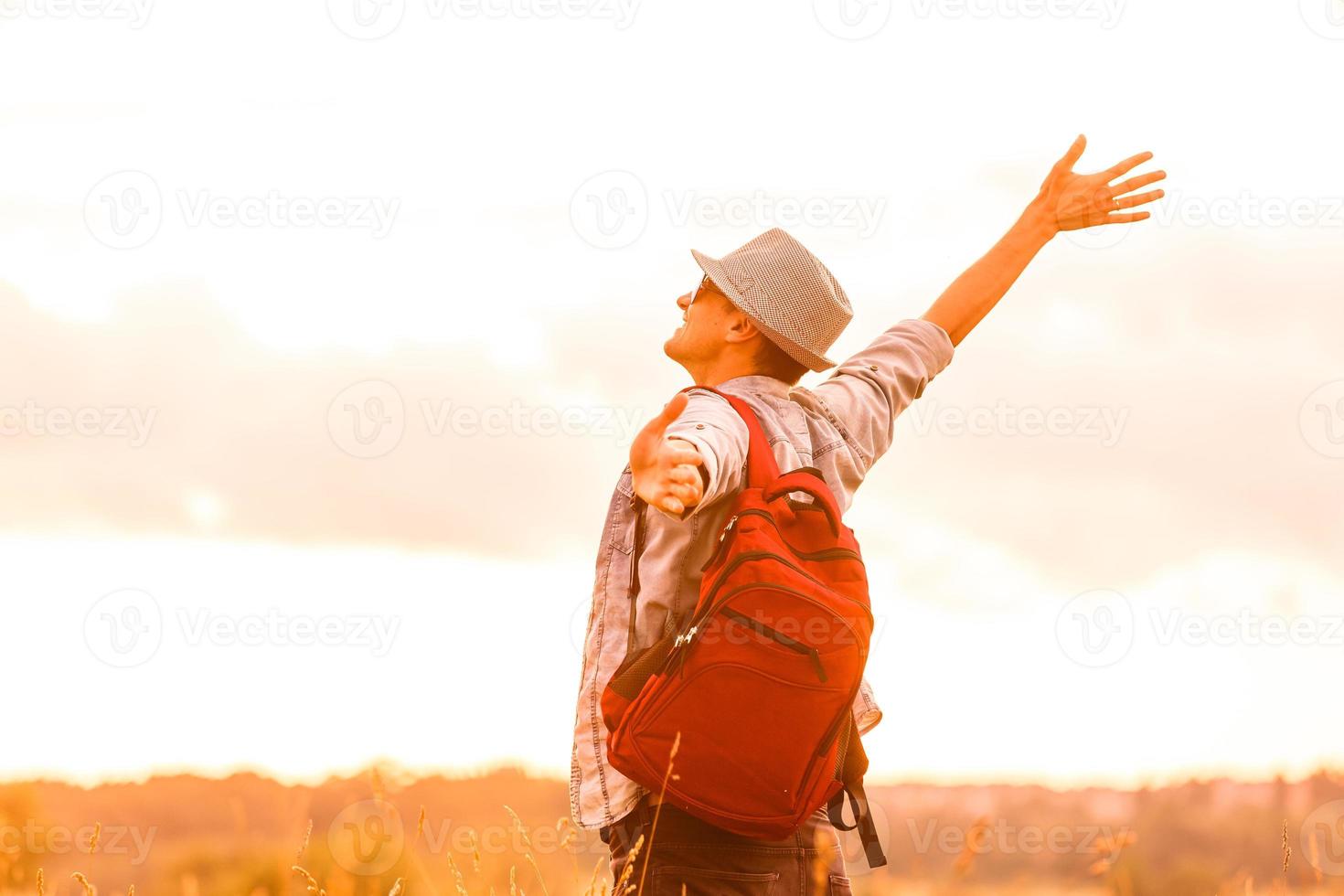 Getting away from it all. Man in open field relaxing looking at the beautiful view. photo