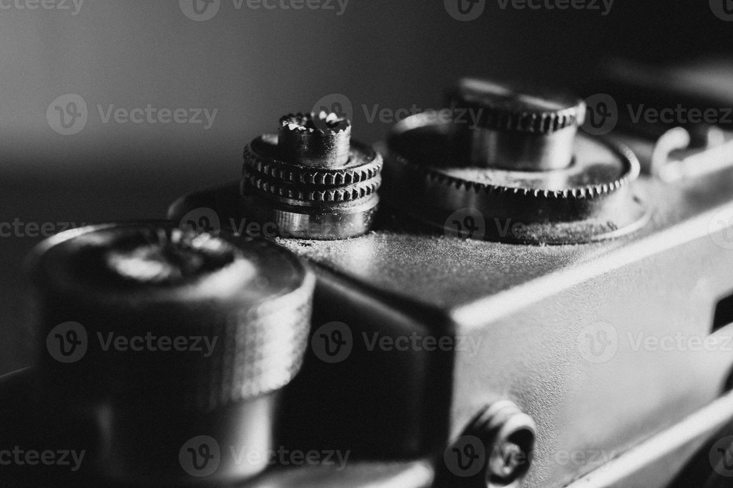 shutter button of an old camera, black and white photo with noise