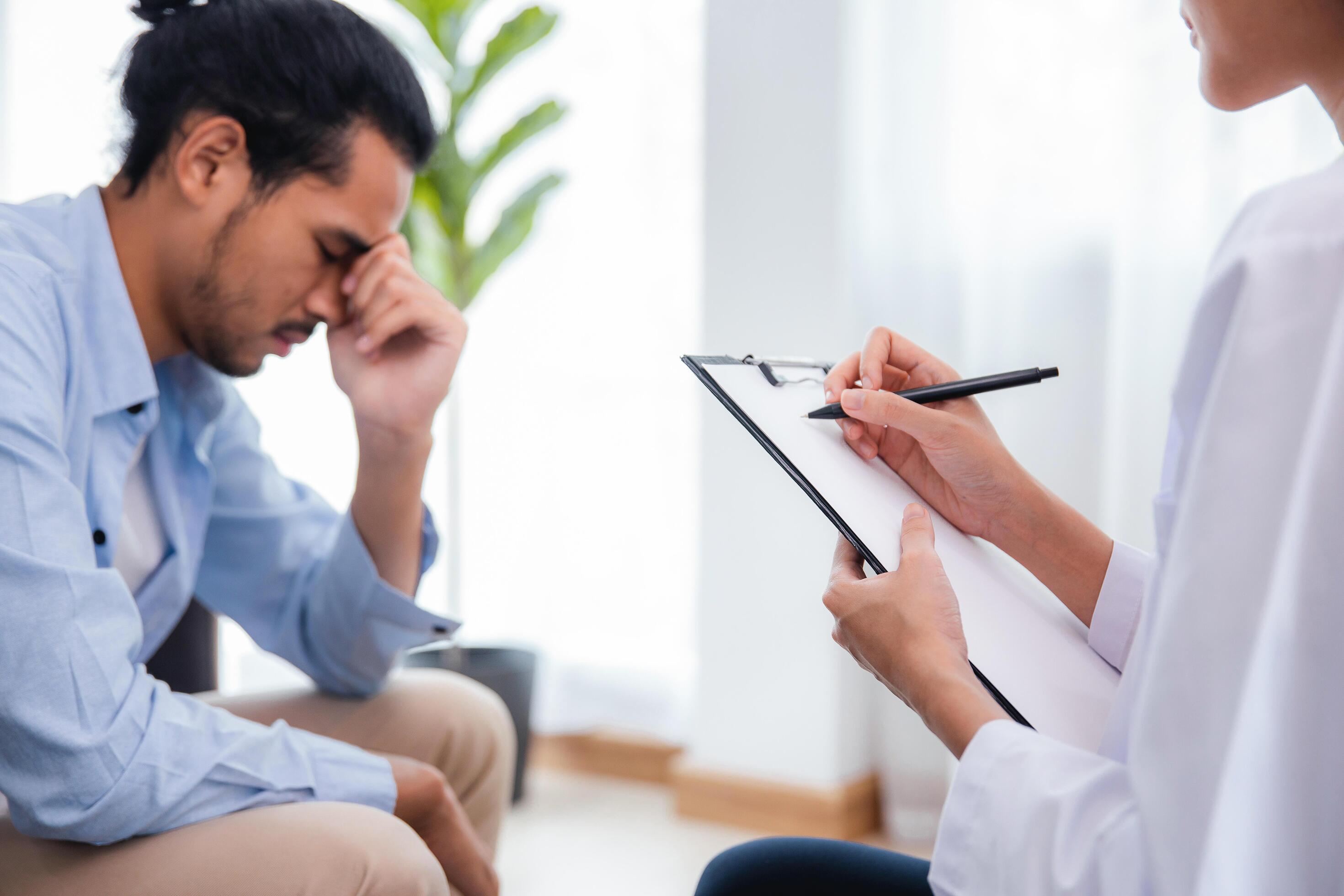 una psicóloga profesional asiática escribe, anota en papel y da la consulta a pacientes